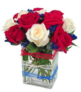 Patriotic roses create a terrific display with red and white roses, accented with purple statice. The clear glass cube is accented with three stylish ribbons in red, white and blue. Celebrate the American Spirit by sending patriotic roses today.