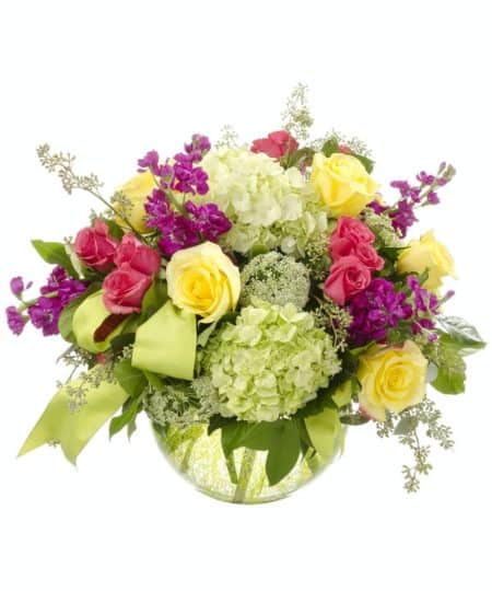 Modern elegance is so quietly stated in the English Garden bouquet. The large bubble bowl is brimming with green hydrangea, yellow roses, hot pink spray roses and purple stock, with queen anne's lace and other greenery. It's available in two sizes and will surprise and delight anyone who receives it.