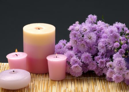 3 pink candles with puple carnations