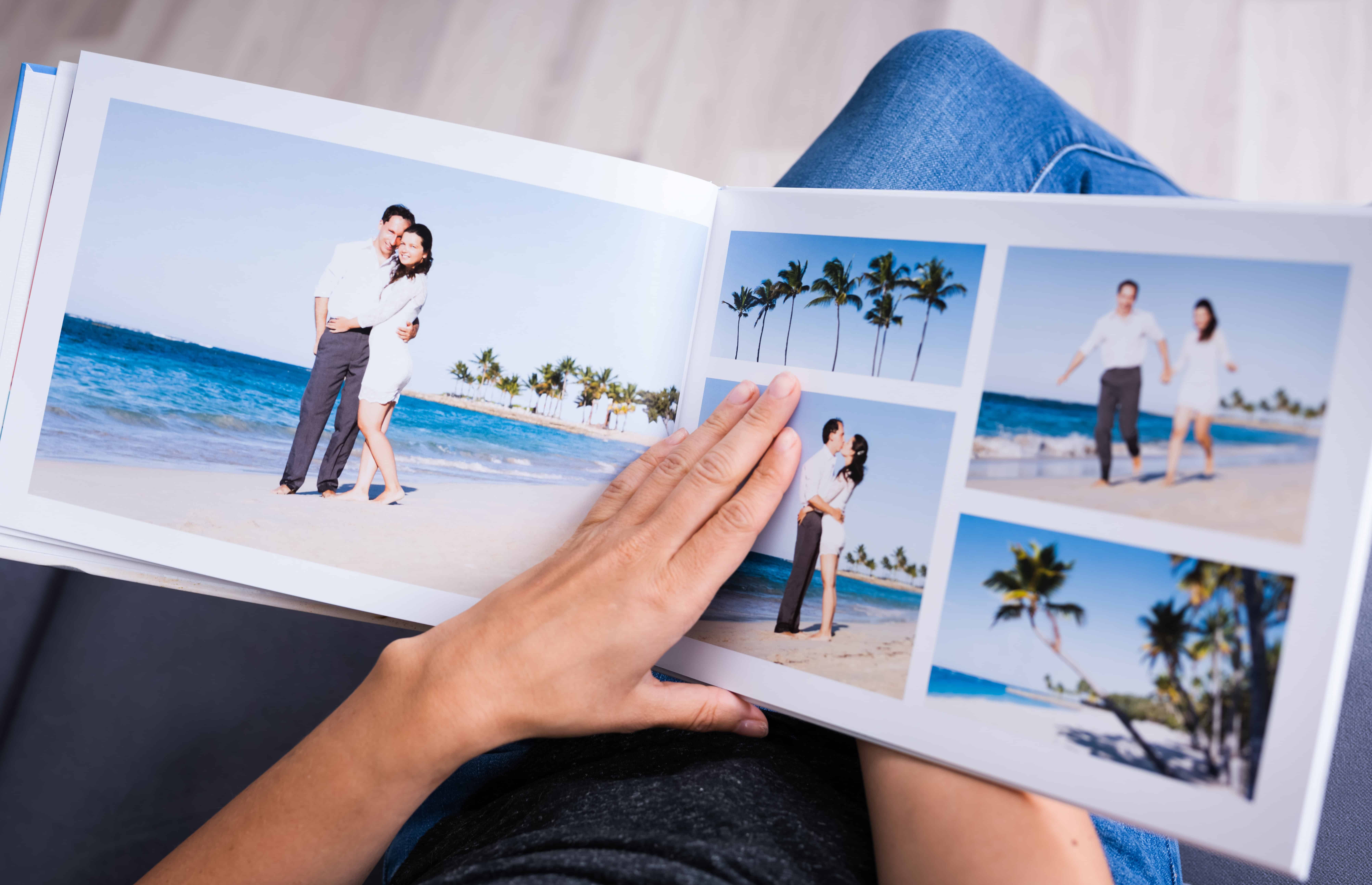 Open photo book with pictures of a couple on a beach
